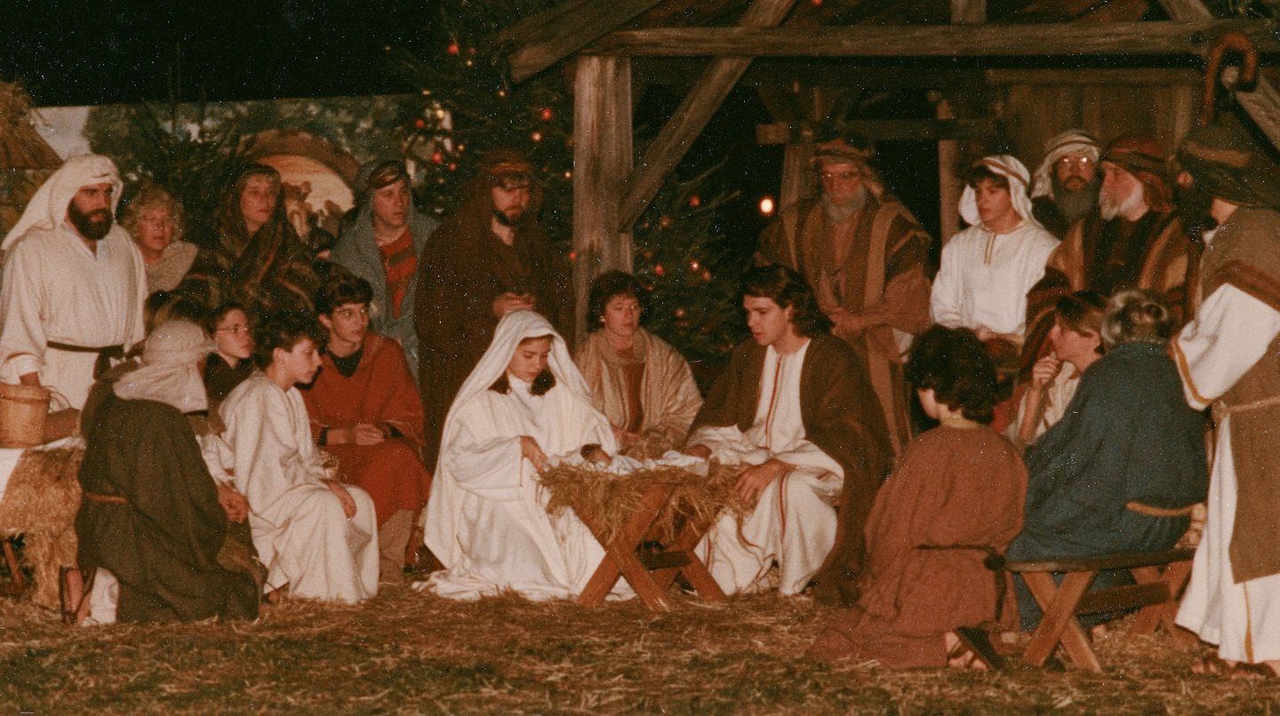 An earlier year's manger scene, the cast gathered under the stable roof